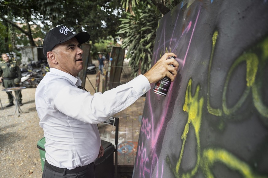 Swiss Federal President Alain Berset sprays his name on a blackboard after visiting the Cultural Center Casa Kolacho in the Comuna 13 neighborhood, on Wednesday, August 9, 2023 in Medellin, Colombia. ...