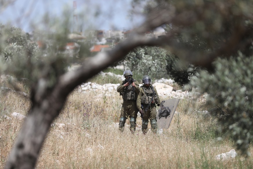 epa09930117 Israeli soldiers take position during clashes with Palestinians after a demonstration against Israel&#039;s settlements on the lands of the Kafr Qadoum village, near the West Bank city of  ...