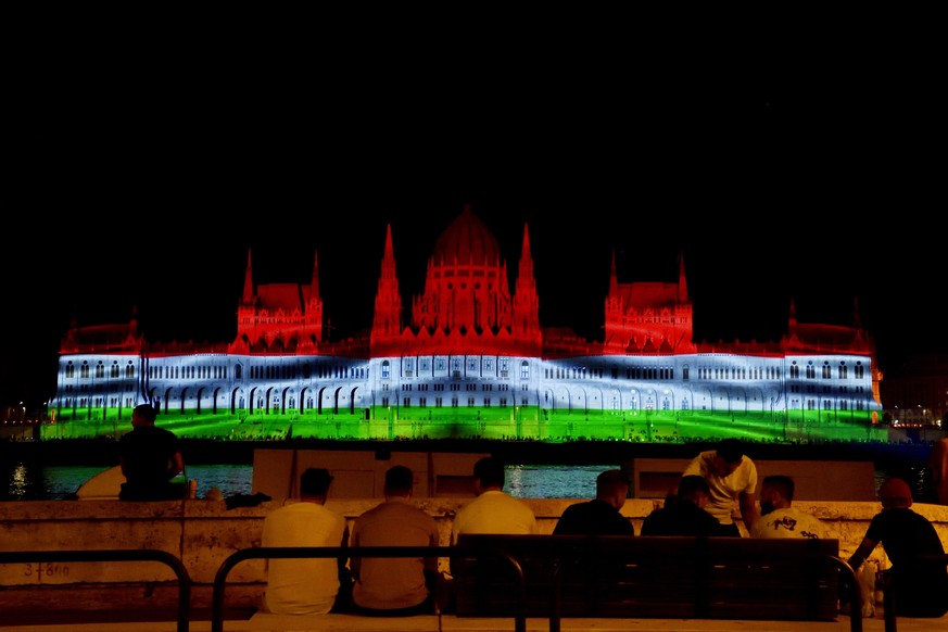 The colors of the Hungarian flag illuminate the Parliament building to mark the national holiday celebrating Hungary's statehood in Budapest, Hungary, Saturday, Aug. 20, 2022. State founder St. S ...