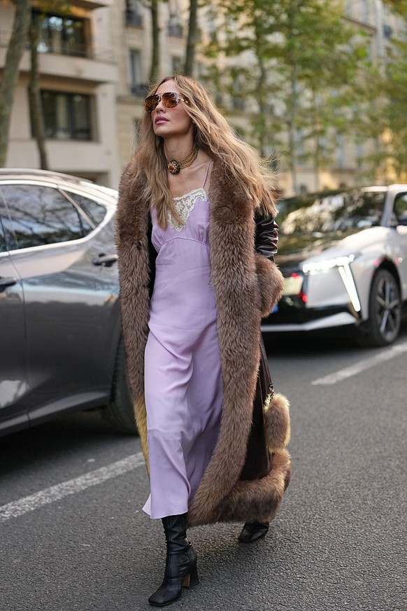 BERLIN, GERMANY - DECEMBER 10: Sonia Lyson is seen wearing black, oval-shaped Vehla sunglasses. Her outfit is cream-colored, consisting of a long, oversized faux fur coat that reaches her ankles. Unde ...