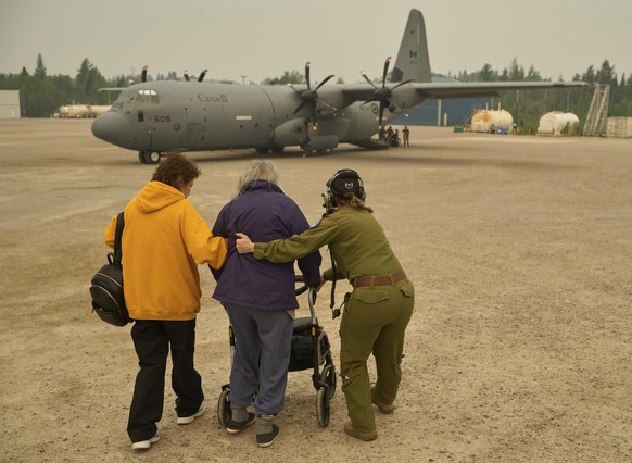 Members of the Royal Canadian Air Force help evacuees board a C-130 Hercules aircraft in Norway House, Manitoba, Tuesday, June 3, 2025, at the Norway House Airport as crews continue to fight wildfires ...