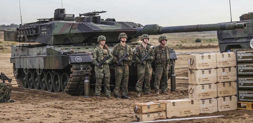 epa10248363 Soldiers stand next to a Leopard 2 battle tank during a media presentation for the annual Land Operation Exercise of the German armed forces Bundeswehr in Bergen, northern Germany, 17 Octo ...