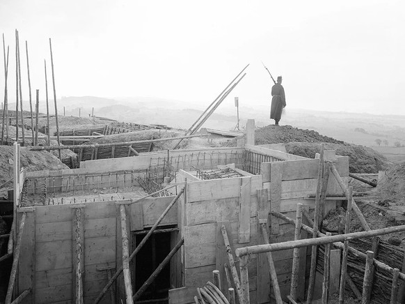 Un soldat surveille le gros œuvre des fortifications de Morat. Cette photo date vraisemblablement de la fin de l’année 1914.
https://commons.wikimedia.org/wiki/File:Betonierte_Unterst%C3%A4nde_noch_im ...
