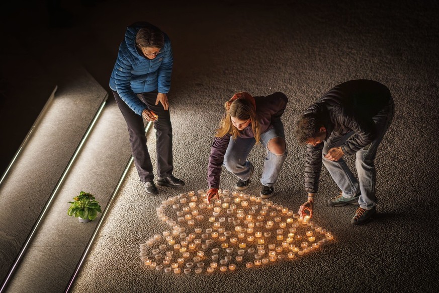People light candles as they attend a ceremony following the discovery of 5 ski tourers who had died near Tete Blanche in the Swiss alps mountains, in Vex, Switzerland, Monday, March 11, 2024. Five cr ...