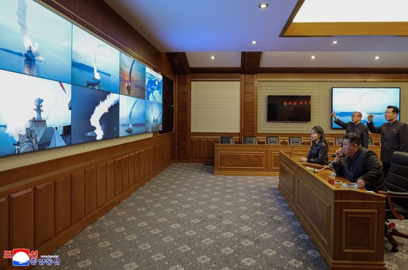This photo provided by the North Korean government shows its leader Kim Jong Un, front right, and his daughter, second right at front, watch what it says the cruise missiles launches from the naval de ...