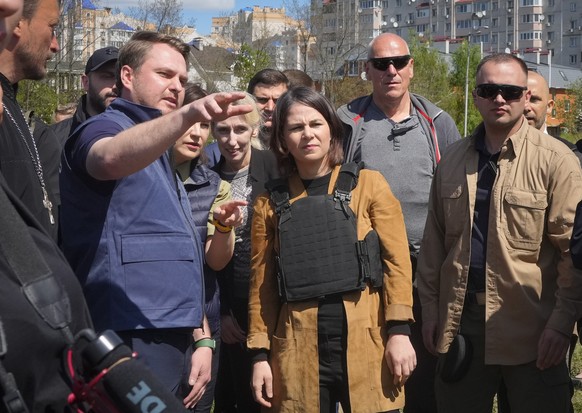 German Foreign Minister Annalena Baerbock, center, and a Ukrainian War Prosecutor talk as they stand near a mass grave in Bucha, on the outskirts of Kyiv, Ukraine, Tuesday, May 10, 2022. (AP Photo/Efr ...
