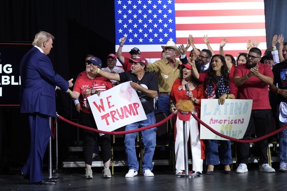 Republican presidential nominee former President Donald Trump, left, greets supporters as he arrives to speak during a campaign event at the Linda Ronstadt Music Hall, Thursday, Sept.12, 2024, in Tucs ...
