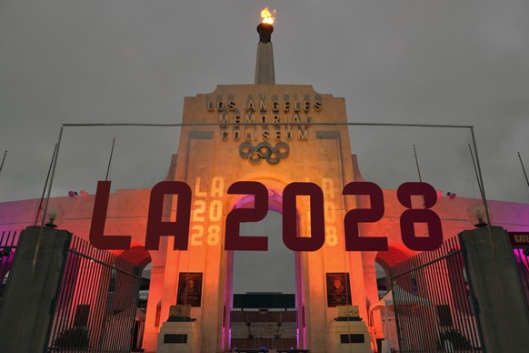 FILE - An LA 2028 sign is seen in front of the Olympic cauldron at the Los Angeles Memorial Coliseum, Wednesday, Sept. 13, 2017. (AP Photo/Richard Vogel, File)