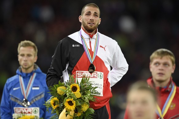Men&#039;s 400m hurdles winner Kariem Hussein from Switzerland, stands on the podium ahead of second placed Rasmus Maegi from Estonia, left, and third placed Denis Kudryavtsev from Russia, right, at t ...