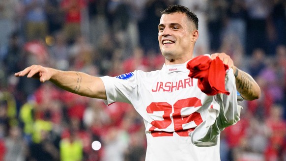 Switzerland&#039;s midfielder Granit Xhaka celebrates the victory and the qualification with the shirt of Switzerland&#039;s midfielder Ardon Jashari after the FIFA World Cup Qatar 2022 group G soccer ...