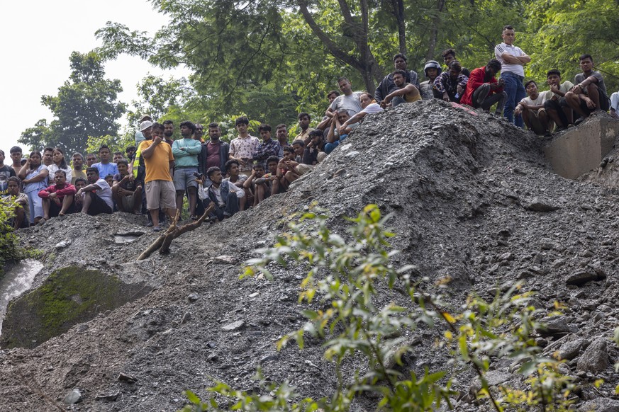 epa11475476 Family members gather while members of a rescue team conduct a search and rescue operation after two passenger buses were swept away by a landslide, at Trishuli River in Simaltal, Chitwan  ...