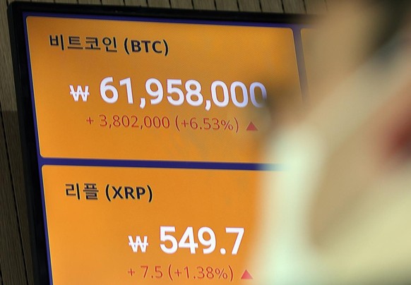 epa09063214 A man is seen in front of an electronic board of a cryptocurrency exchange showing the price of bitcoin shooting to 61,958,000 won (54,372.97 US dollars) in Seoul, South Korea, 09 March 20 ...