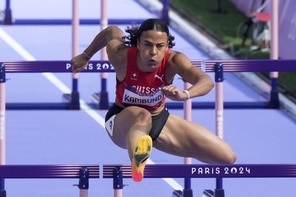 Ditaji Kambundji, of Switzerland, clears a hurdle in a women&#039;s 100 meters hurdles round 1 heat at the 2024 Summer Olympics, Wednesday, Aug. 7, 2024, in Saint-Denis, France. (AP Photo/Martin Meiss ...