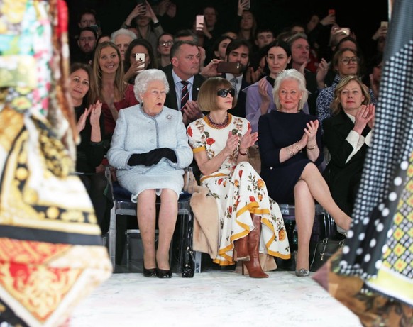 LONDON, ENGLAND - FEBRUARY 20: Queen Elizabeth II sits with Anna Wintour, Caroline Rush (L), chief executive of the British Fashion Council (BFC) and royal dressmaker Angela Kelly (R) as they view Ric ...