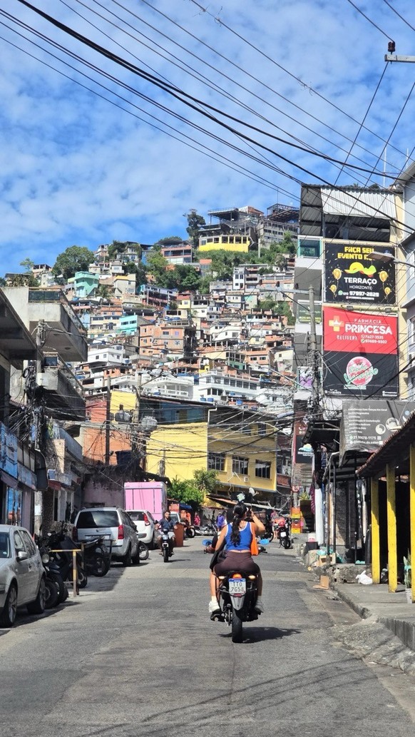 À moto dans la favela: une moto-taxi slalome dans la seule rue de Vidigal, une favela de Rio de Janeiro.