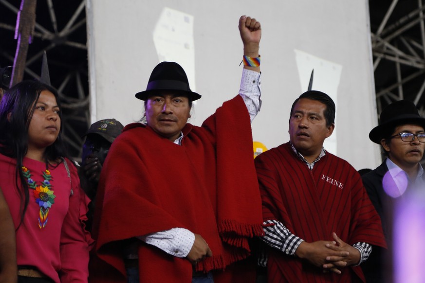 epa10044891 The president of the Confederation of Indigenous Nationalities of Ecuador, Leonidas Iza (2-L), speaks to the indigenous people at the House of Culture at the end of the national strike in  ...