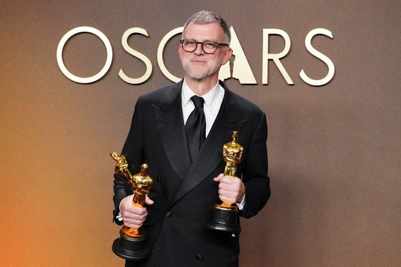 Paul Thomas Anderson, winner of the awards for writing (adapted screenplay), directing, and best picture for "One Battle After Another," poses in the press room at the Oscars on Sunday, Marc ...