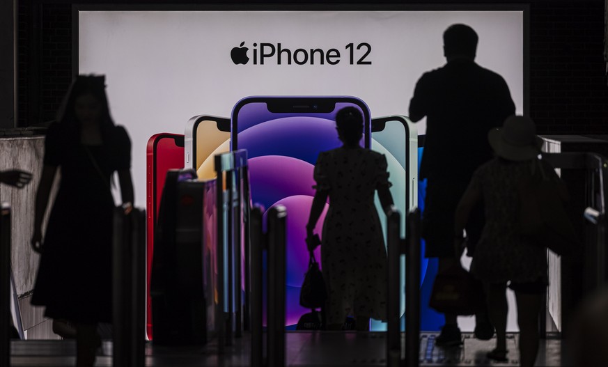epa09332899 People enter the subway in front of a Apple&#039;s iPhone 12 advertisement, in Shanghai, China, 09 July 2021. According to the National Bureau of Statistics, China&#039;s Consumer Price In ...