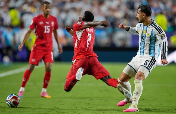 Switzerland's Breel Embolo (7) reacts in a challenge from Argentina's Leandro Paredes (5) during the World Cup quarterfinal soccer match between Argentina and Switzerland in Kansas City, Mo. ...