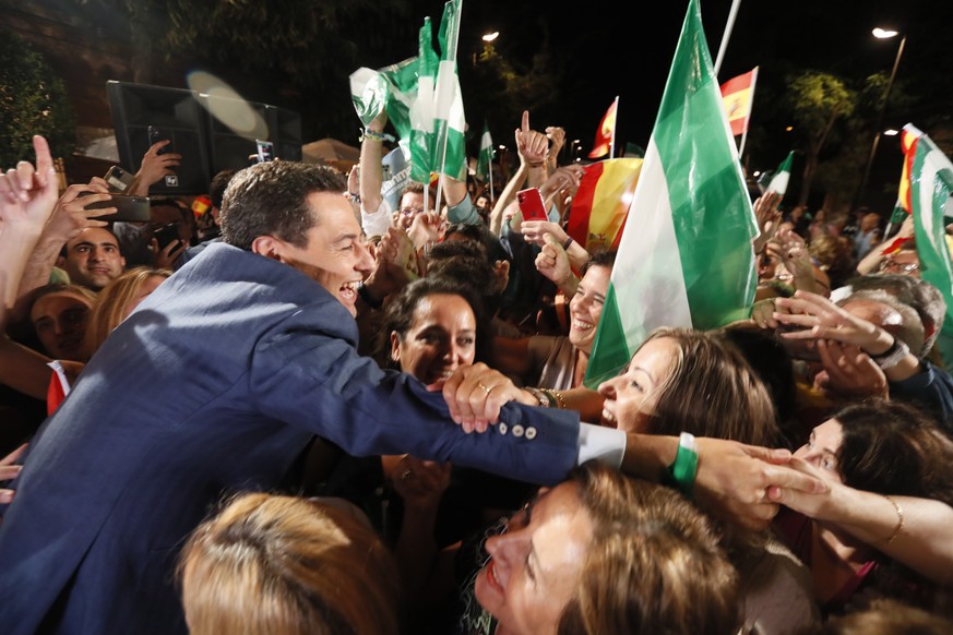 epa10023236 Popular Party&#039;s candidate for Regional President in Andalucia Juanma Moreno (L) greets his supporters in Sevilla, Spain, 19 June 2022. Popular Party&#039;s candidate for the Regional  ...