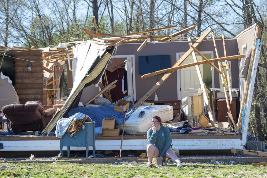 Une femme est assise devant sa maison détruite par une tornade à Adamsville, dans le Tennessee.