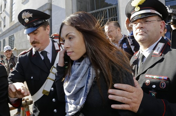 Karima el-Mahroug&#039;s is escorted outside the Milan&#039;s Law court by two Carabinieri police officers after giving her testimony at the trial of three former Berlusconi aides accused with procuri ...