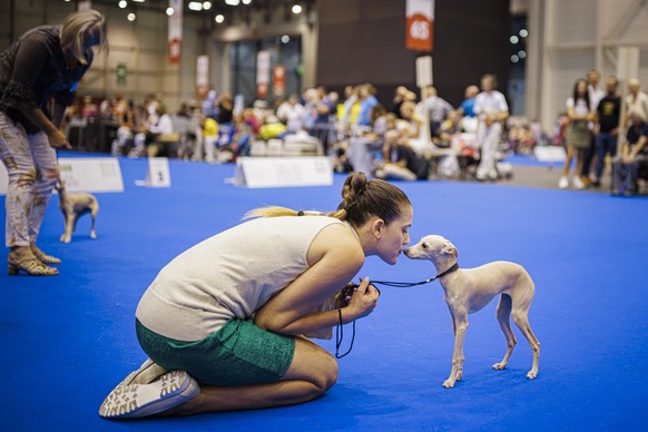 A woman kisses her dog during the "world dog show 2023" competiton in Geneva, Switzerland, Saturday, August 26, 2023. Participants from 80 countires are presenting over 21'500 dogs from ...