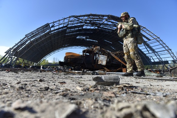 epa09928491 A picture taken during a trip organized by the Ukrainian interior ministry showing a Ukrainian special forces officer near a damaged hangar containing the wreckage of the largest Ukrainian ...