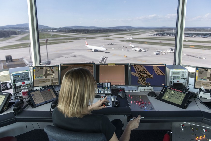 Eine Mitarbeiterin von Skyguide kontrolliert die Monitore und hat Blick auf das Flugfeld, bei Skyguide im Tower des Flughafen Zuerich Kloten, aufgenommen am 10. April 2014. Im Tower am Flughafen Zueri ...