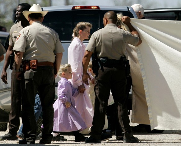 FILE - This April 6, 2008, file photo, shows members of The Fundamentalist Church of Jesus Christ of Latter-day Saints as they are assisted by law enforcement officials to board a San Angelo Independe ...