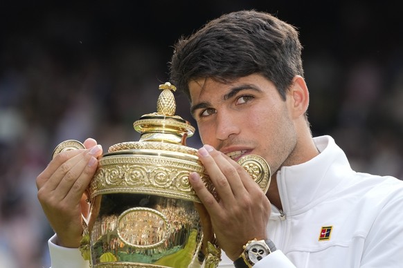 Carlos Alcaraz of Spain holds his trophy after defeating Novak Djokovic of Serbia in the men&#039;s singles final at the Wimbledon tennis championships in London, Sunday, July 14, 2024. (AP Photo/Kirs ...