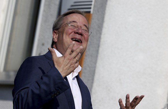 Armin Laschet, Christian Democratic Union parties candidate for Chancellery and Minister President of North Rhine-Westphalia laughs after he casts his vote for the German parliament election in Aachen ...