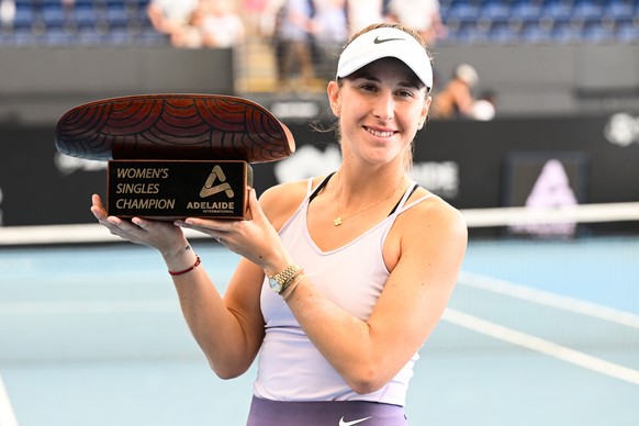 epa10404224 Belinda Bencic of Switzerland accepts the winners trophy after defeating Daria Kasatkina of Russia during the 2023 Adelaide International Tennis Tournament at the Memorial Drive Tennis Cen ...