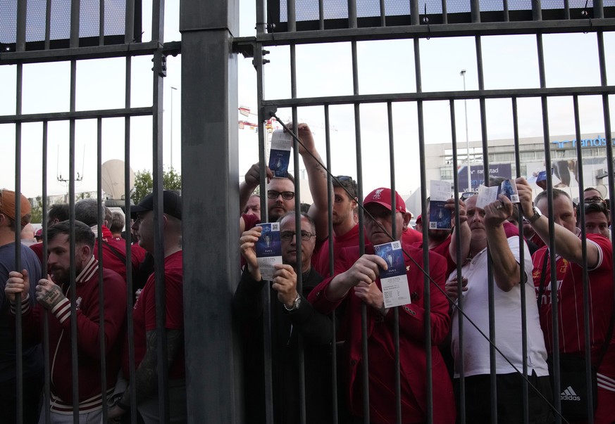 FILE - Liverpool fans wait in front of the of the Stade de France prior the Champions League final soccer match between Liverpool and Real Madrid, in Saint Denis near Paris, Saturday, May 28, 2022. A  ...