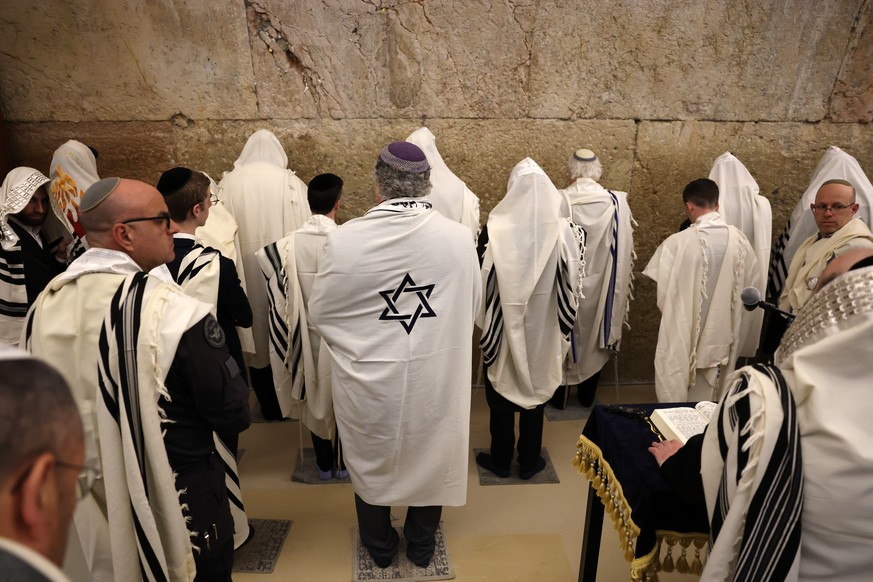 epa12870133 Orthodox Jews wearing prayer shawls recite the Priestly Blessing (Birkat Kohanim) at the Western Wall tunnels in the old city of Jerusalem, 05 April 2026. Israeli police have capped public ...