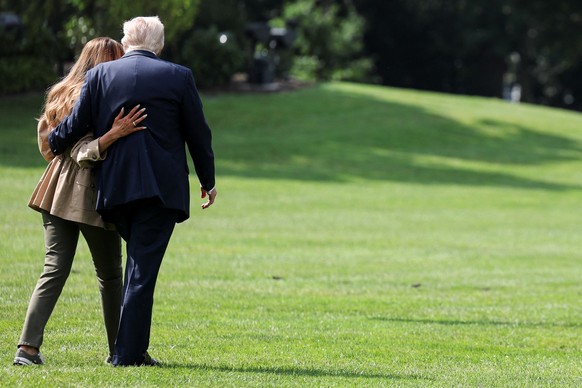 U.S. President Donald Trump and first lady Melania Trump walk towards Marine One, as they depart for travel to Texas to tour areas affected by deadly flash flooding, from the South Lawn of the White H ...
