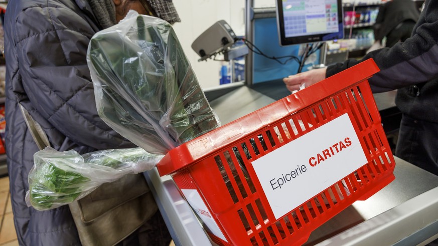 Une personne dans la precarite fait ses achats dans l'Epicerie Caritas de la rue de Carouge, ce vendredi 10 fevrier 2023 a Geneve. Les epiceries Caritas proposent aux personnes disposant d'u ...