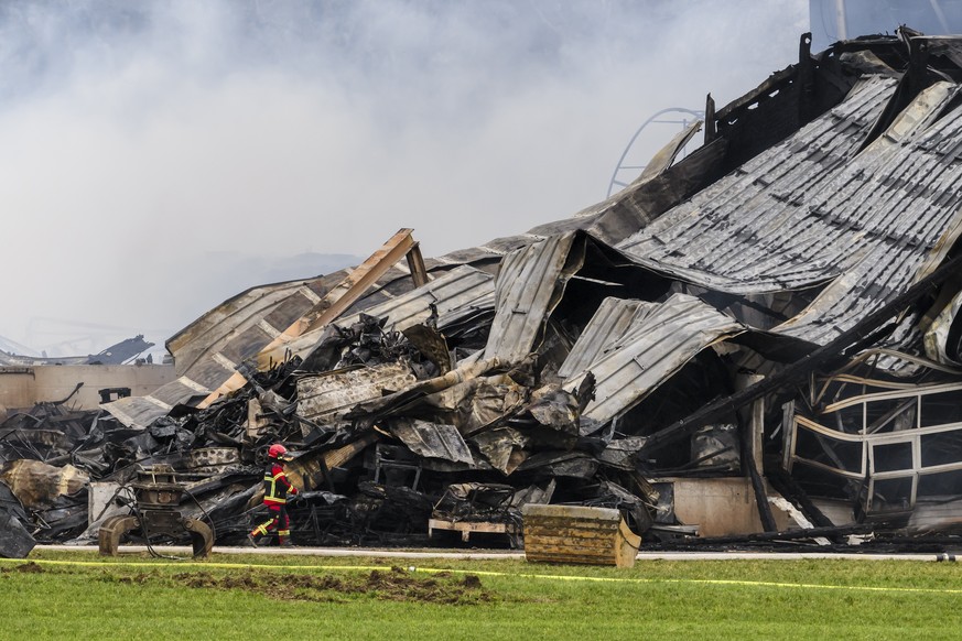 Un pompier marche autour des decombres apres l&#039;incendie d&#039;une ferme le jeudi 21 decembre 2023 a Bottens dans le canton de Vaud. Plus de 500 animaux, principalement des bovins adultes et des  ...