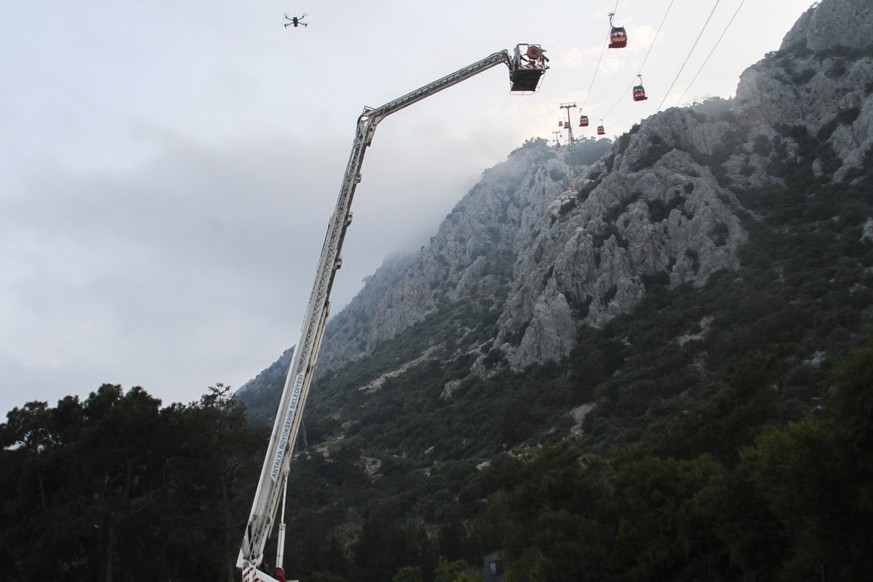 A rescue team work with passengers of a cable car transportation systems outside Antalya, southern Turkey, April, Friday 12, 2024. A cable car disaster in southern Turkey left one person dead and seve ...