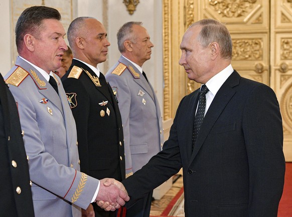 FILE - Russian President Vladimir Putin, right, and Lt. Gen. Alexander Lapin, the chief of Russia's Central Military District, left, attend an awarding ceremony in the Kremlin in Moscow, Russia, on Ma ...