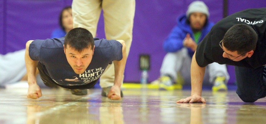 March 21, 2014 - Fairbanks, AK, U.S. - An official, right, watches to make sure Team Northwest Territories James Kalinek clears the floor during the Arctic Winter Games knuckle hop Friday, March 21, 2 ...