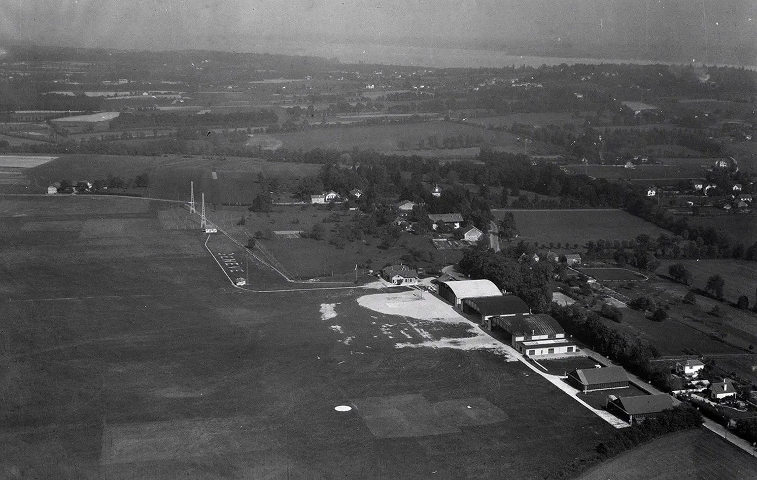 Vue aérienne de l’aéroport de Genève-Cointrin. Photo prise en 1931 par le pionnier de l’aviation Walter Mittelholzer.
https://ba.e-pics.ethz.ch/#detail-asset=4436e8ad-bddd-4c91-ab62-337818f95759
