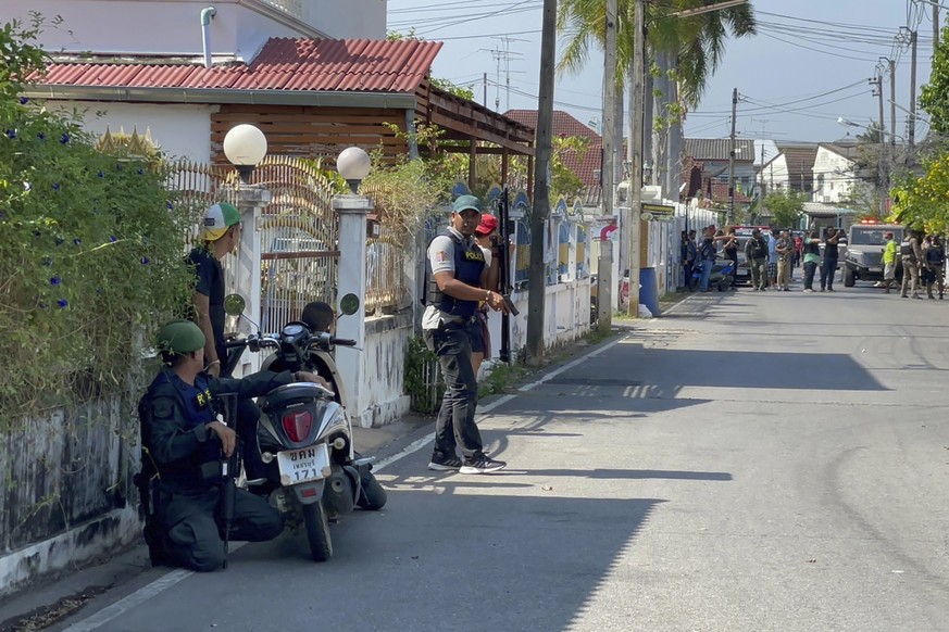 Policemen with guns take positions on a street near the neighborhood of a gunman&#039;s house in Phetchaburi province, southwest of Bangkok, Thailand, Wednesday, March 22, 2023. Police in Thailand hav ...