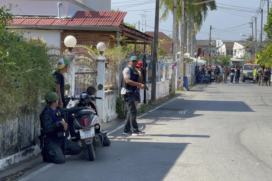 Des policiers prennent position non loin de la maison du tireur, dans la province de Phetchaburi, près de Bangkok.