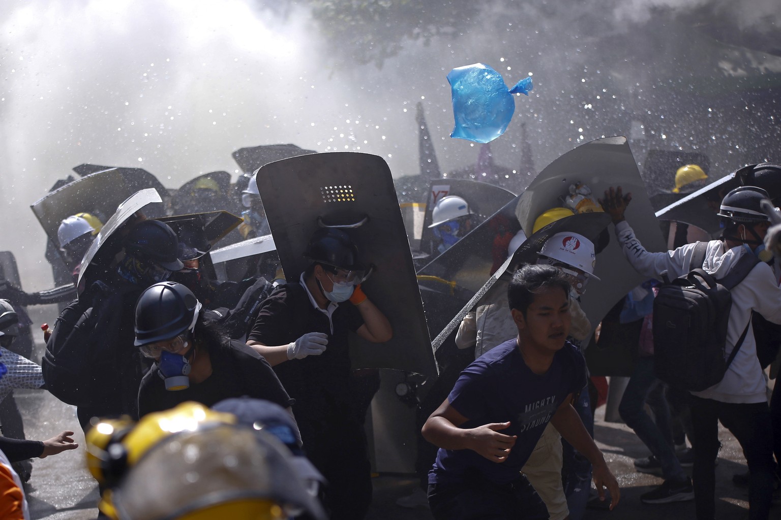 Protesters are dispersed as riot police fire tear gas during a demonstration in Yangon, Myanmar, Monday, March 8, 2021. Myanmar security forces continued to clamp down on anti-coup protesters, firing  ...