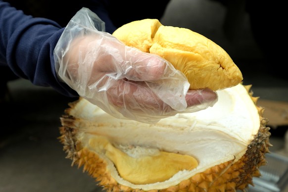 epa11255062 A person cuts a durian for sale in Hanoi, Vietnam 02 April 2024. Vietnam&#039;s durian market has grown strongly, leading to its agricultural products export growth during the first months ...