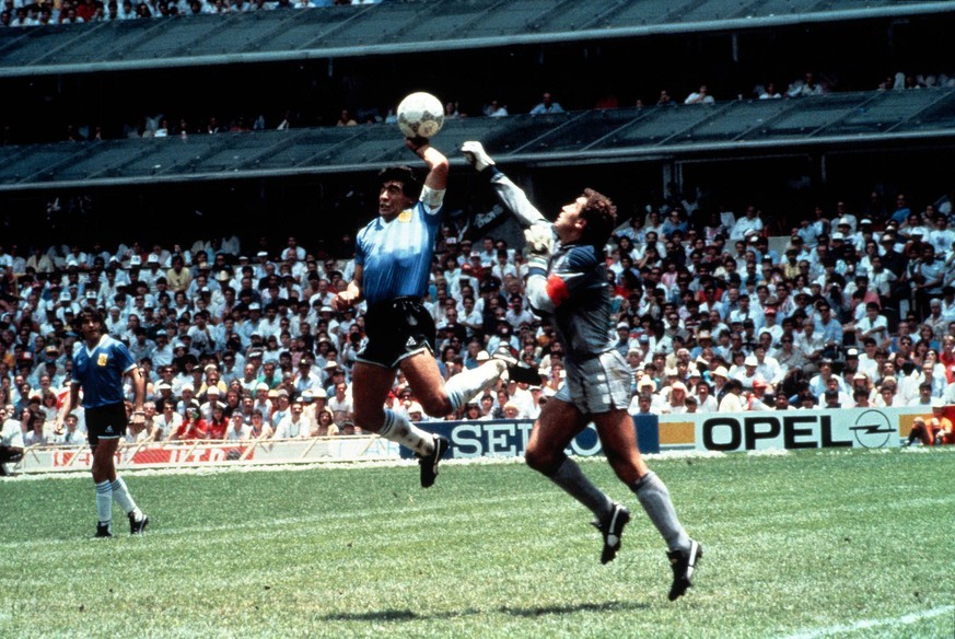 Eine beruehmte und vieldiskutierte Szene der Fussball-WM-Geschichte vom 22. Juni 1986 mit Tatort Aztekenstadion in Mexiko-Stadt: Die argentinische Fussball-Legende Diego Maradona (M) boxt in der 51. M ...