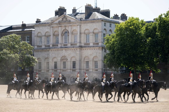 Members of the Household Cavalry kick up the dust as they ride across Horse Guards Parade, London, Tuesday July 19, 2022. Britain shattered its record for highest temperature ever registered Tuesday, ...