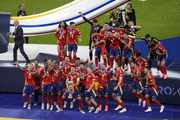 Spain&#039;s players celebrate with the trophy after winning the final match against England at the Euro 2024 soccer tournament in Berlin, Germany, Sunday, July 14, 2024. (AP Photo/Thanassis Stavrakis ...