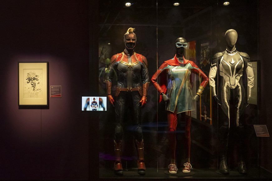 Captain Marvel (zu sehen in Captain Marvel, 2019), Ms. Marvel mit Armreif (zu sehen in Ms. Marvel, 2022) und Captain Monica Rambeau (zu sehen in The Marvels, 2023), von links, in der Ausstellung Marve ...